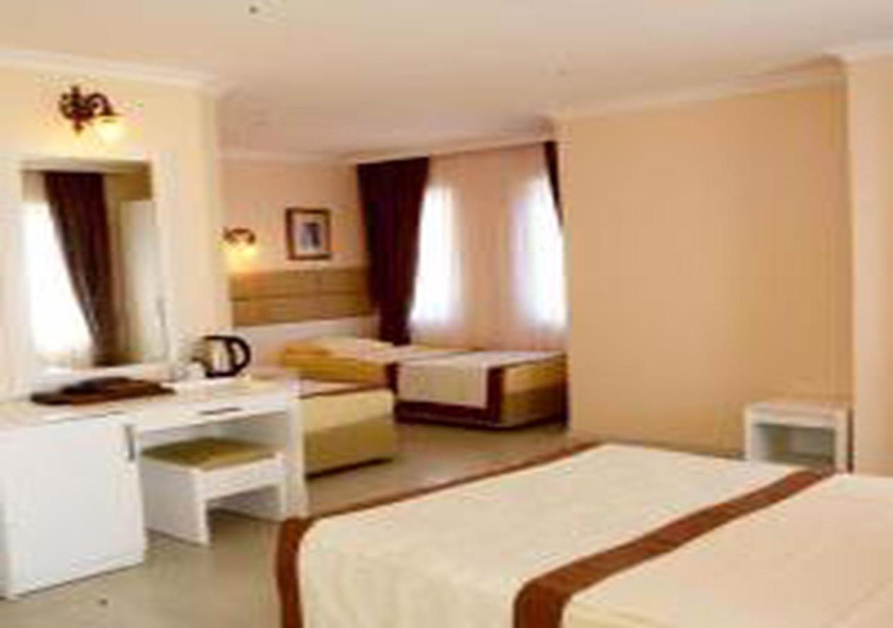 Miramor Hotel & Spa Antalya Exterior foto The photo shows a hotel room with two beds and a cozy, inviting atmosphere. One bed is larger, possibly a queen or king size, and is draped with a light-colored bedspread that has a brown accent. The room has light-colored walls and natural light str